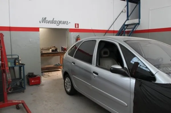 Hatch prateado parado em frente ao vão sinalizado Montagem, ao lado da bancada de ferramentas